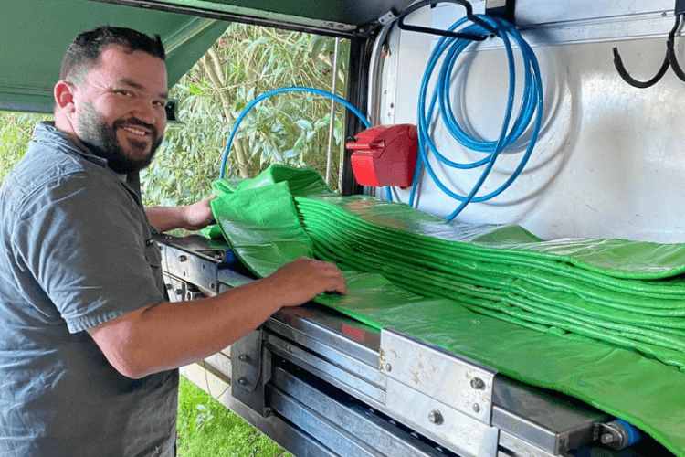 Smiling Relining employee in work truck working on green pipes