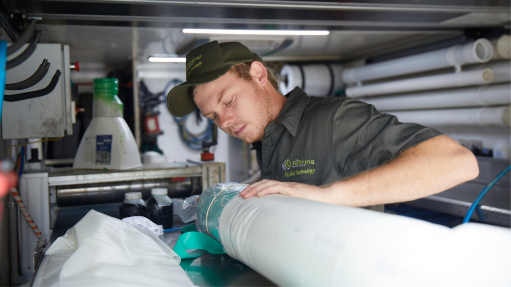 Relining employee working on a drain pipe within work vehicle