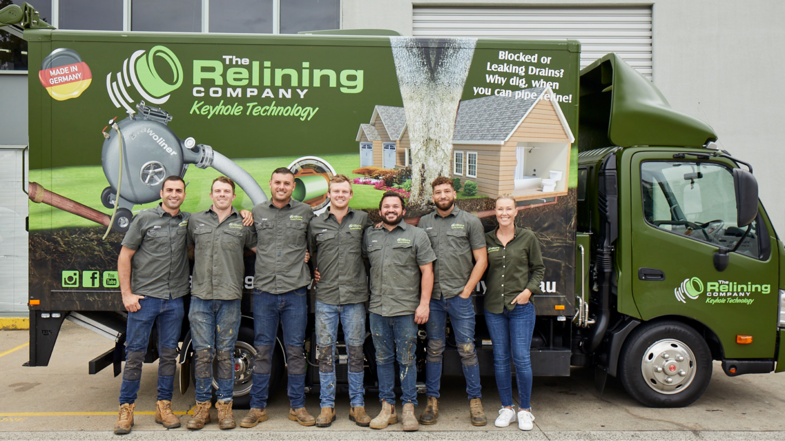 Relining employees-standing in front of work vehicle smiling