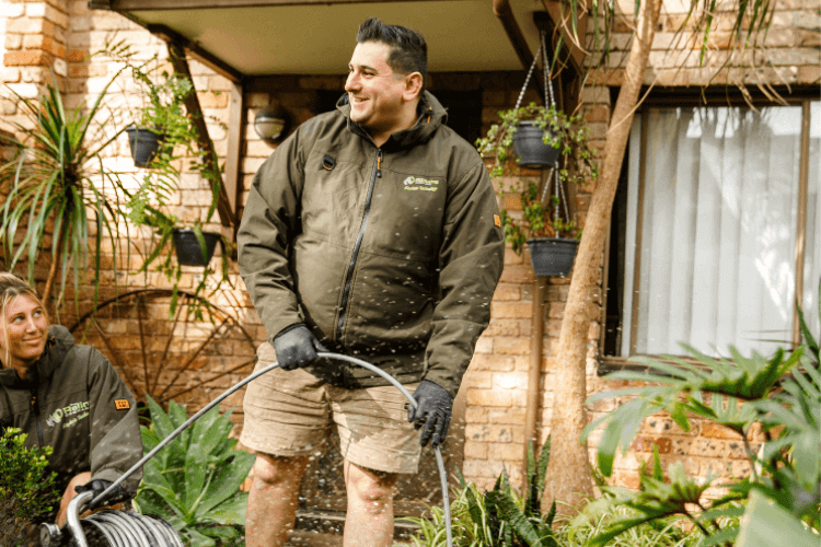 Relining employees washing out drain pipes